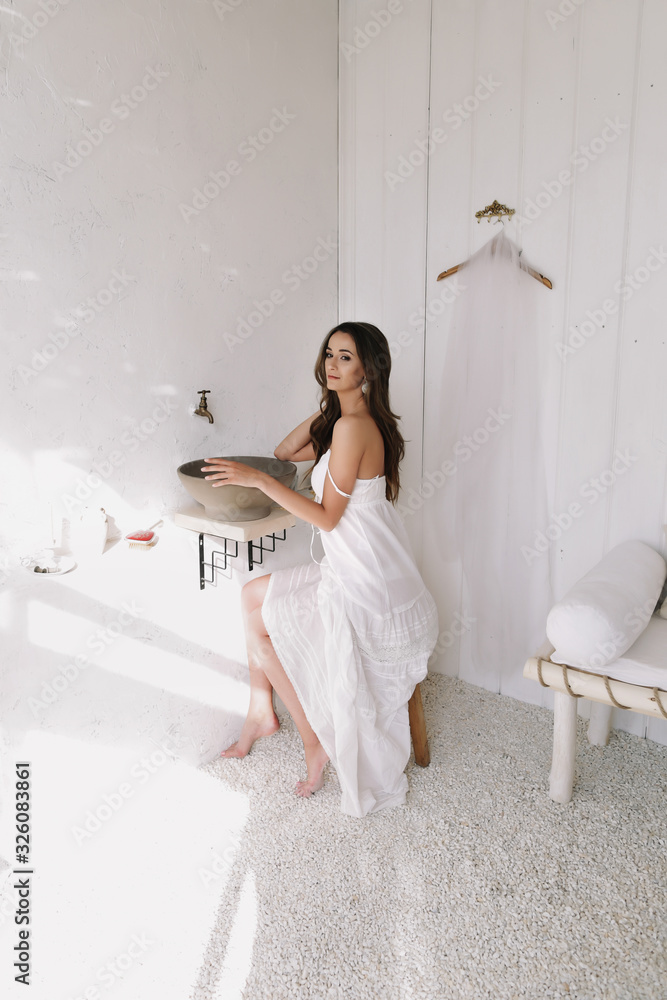 Naklejka premium Portrait of a young beautiful woman. Bride in elegant classic wedding dress. Morning of the bride. Wedding preparations.