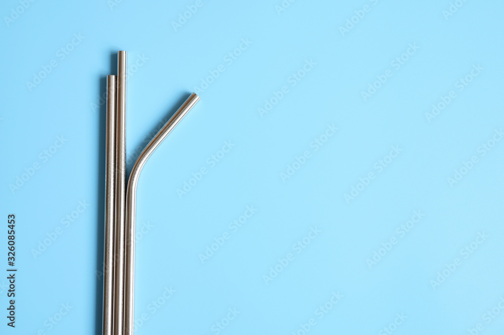 reusable metal stainless steel drinking straws on a blue background. space for text reusable metal stainless steel drinking straws on a blue background. space for text