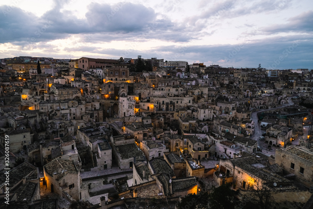 Illuminated perspective view of old town skyline of matera,sunset lights italy 
