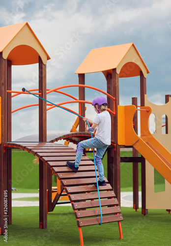 happy boy climbing into colorful activity tower on the playground, children development and entertainment, playground equipment photo