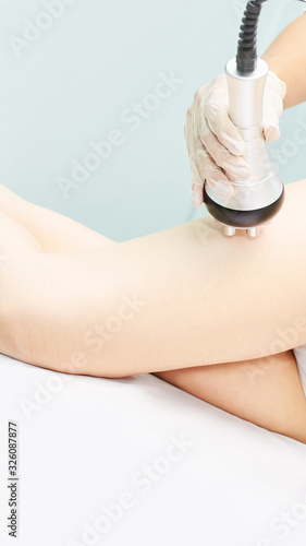 Perfect body radio treatment. Woman at spa procedure. Doctor hand and girl body. RF cosmetology lifting. Legs.