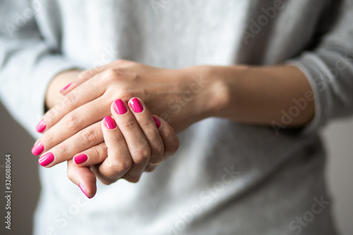 Closeup photo of manicure, women hands with perfect pink polish