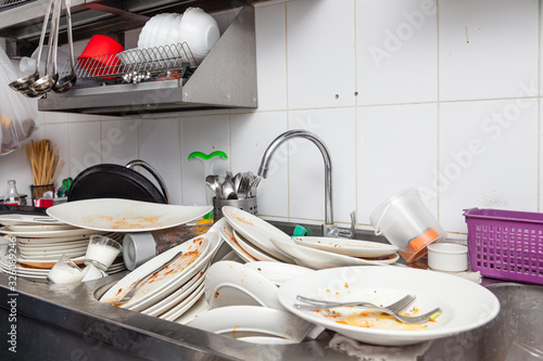 Metal sink full of dirty dishes, crockery, tableware