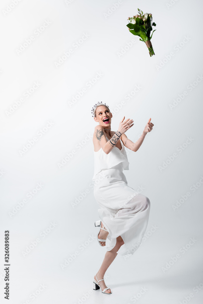happy beautiful tattooed bride throwing bouquet on white happy beautiful tattooed bride throwing bouquet on white