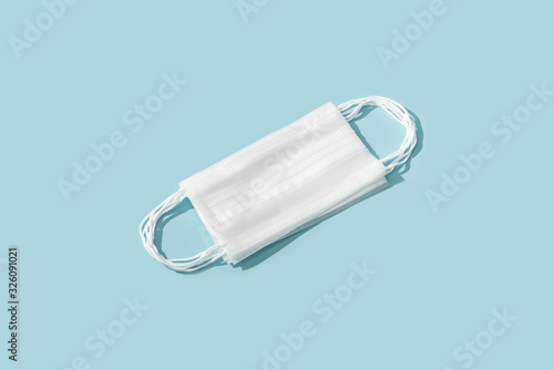 Flat lay composition with protective white face mask on color background