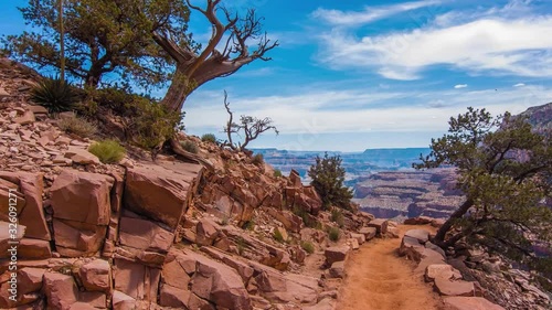 A Steep Hiking Trail With A Few Trees At The Edge Of The Boulder Under The Clear Blue Sky. -wide shot photo