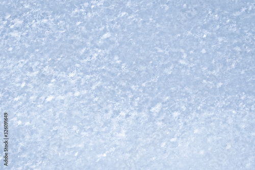 The texture of freshly fallen snow. Christmas template for design. Clearly visible individual snowflakes. Winter background.