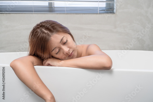Young and beautiful girl using phone relaxing in the retro bath indoors
