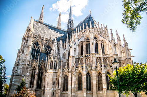 Canvas Print Votivkirche church among green trees. Vienna. Austria