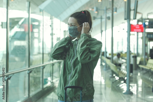 Woman wearing protective mask in airport, Coronavirus contagion fears concept