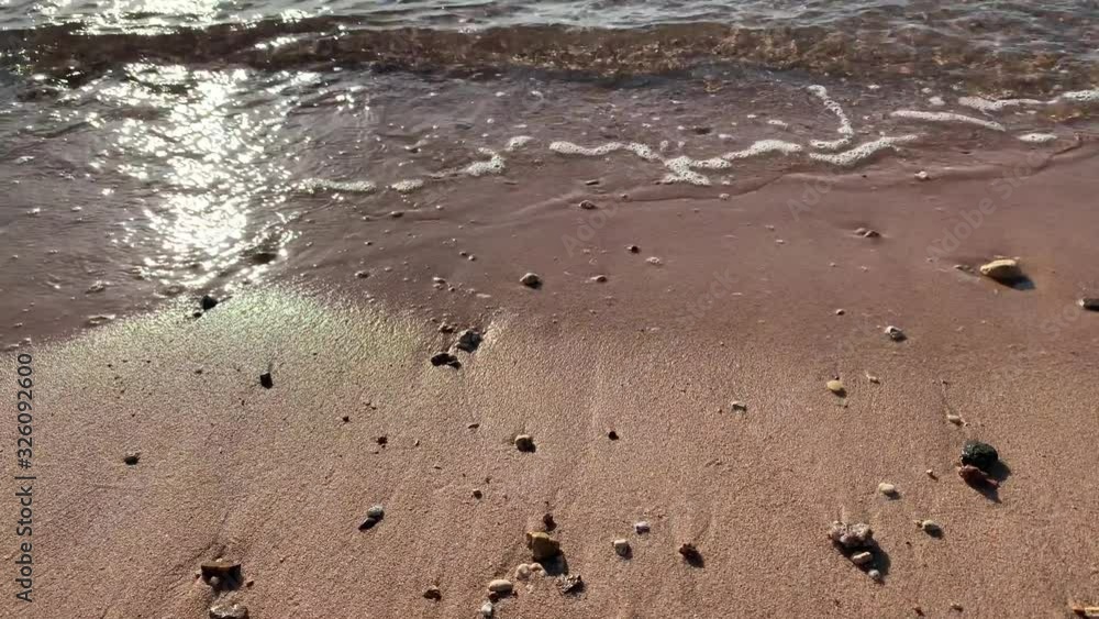 Red sea. Sandy seashore. Summer beach. Sea waves with footprints on the sandy beach. Sand by the Sea Red sea. Sandy seashore. Summer beach. Sea waves with footprints on the sandy beach. Sand by the Sea