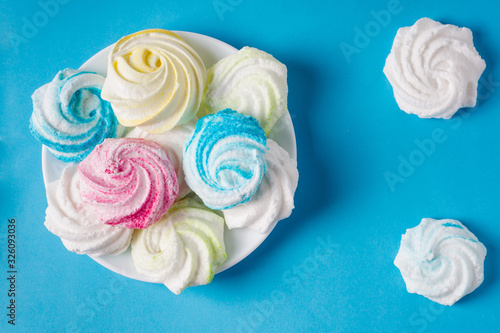 Homemade sweet colored meringue on blue background. .Dessert.