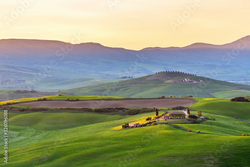 Sunspot on a farm in the rolling Tuscan landscape at sunrise