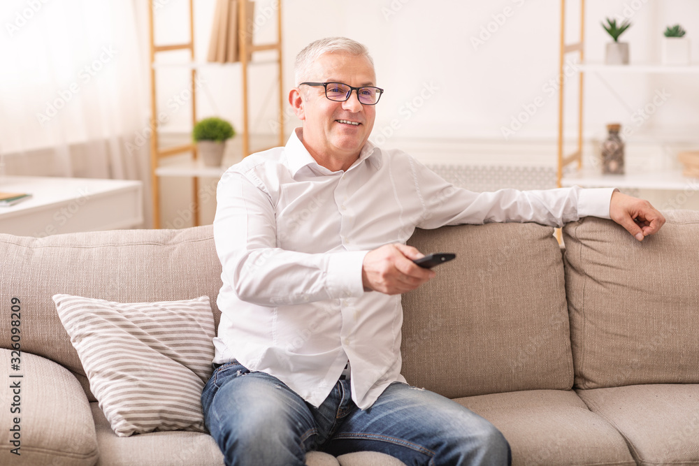 Elderly man watching tv sitting on sofa Elderly man watching tv sitting on sofa