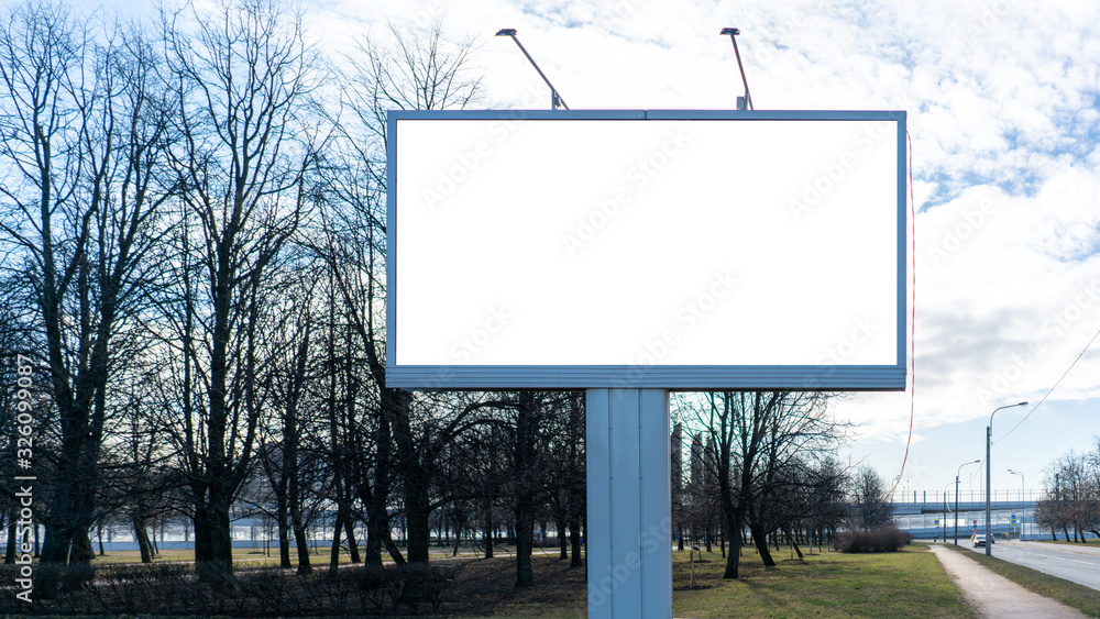 Obraz premium Advertising billboard metal, large horizontal. Behind a park with trees. With white margin for mock-up posters