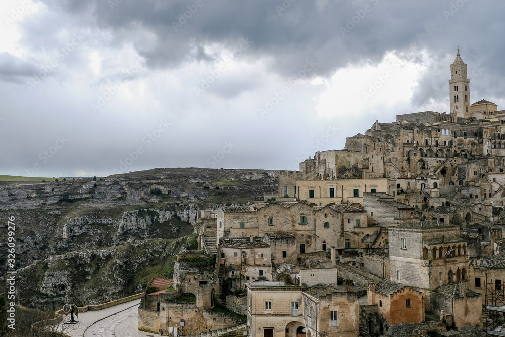 High view of of old matera town,italy,people and cars,traditional stone houses