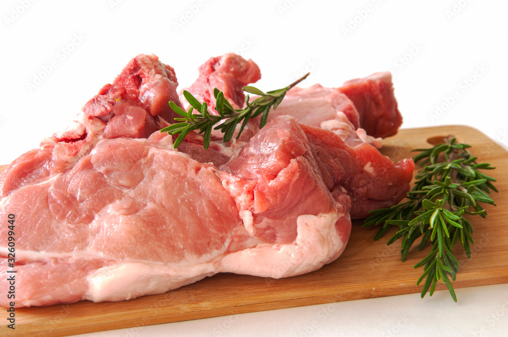 Raw pork fillet on a cutting board on a white background