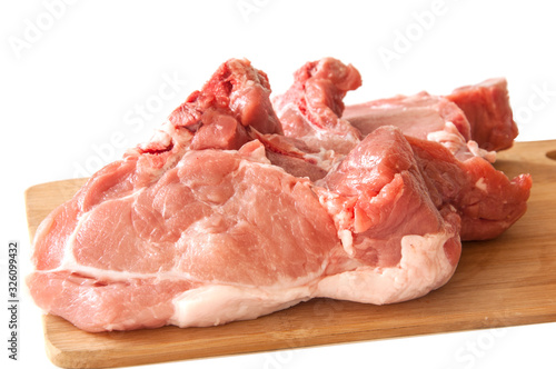 Raw pork fillet on a cutting board on a white background