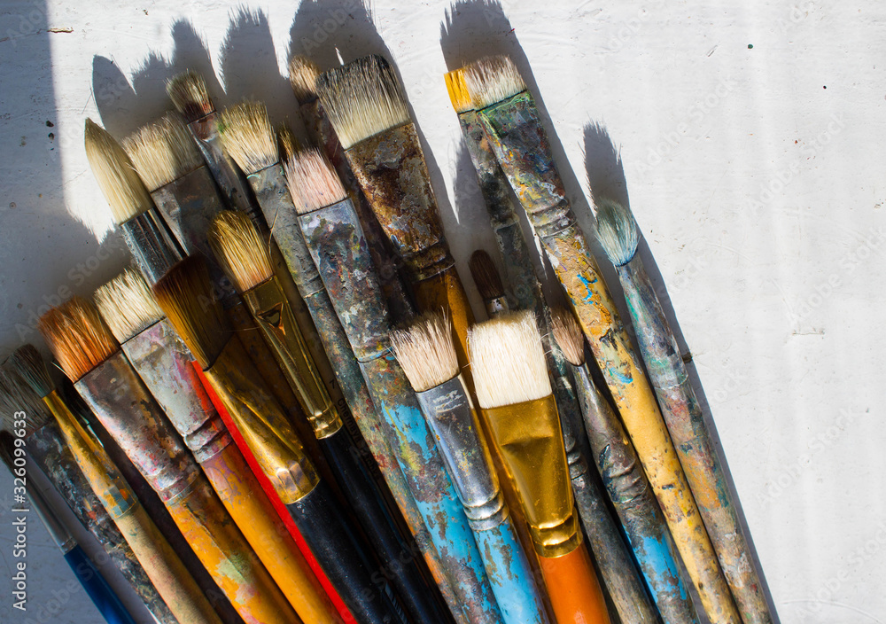 Obraz premium Workplace painter palette with colors and brushes. Palette of colors, creative disorder, art.