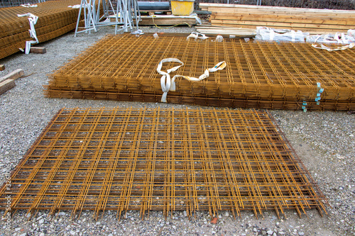 a stack of rusty brown steel mesh mats are lying on a building site