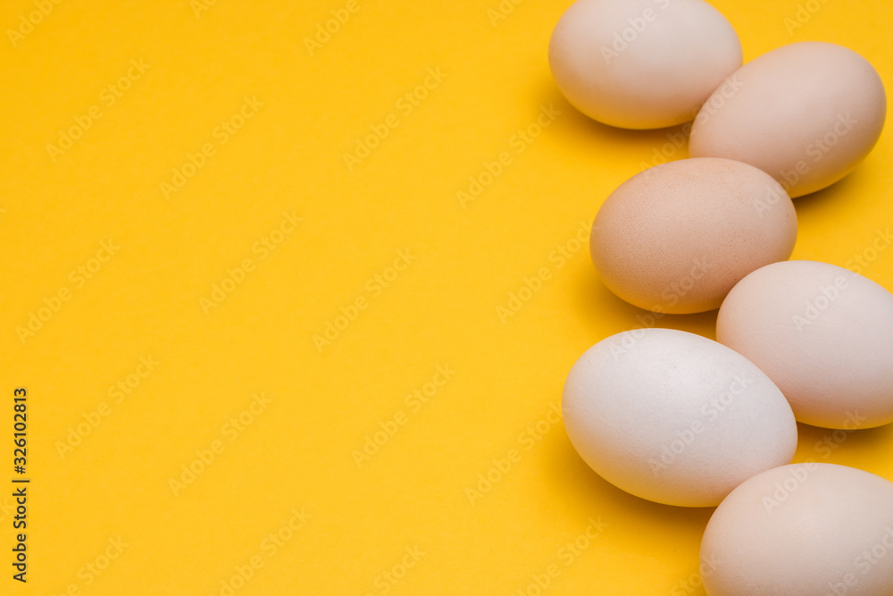natural ecological eggs on yellow background in a row with copyspace
