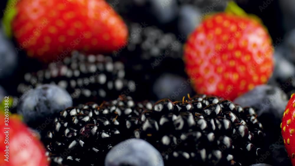Macro 4k video of camera sliding over lots of blackberry strawberry and blueberry lying on desk. Perfect abstract background for organic food and healthy nutrition. Macro 4k video of camera sliding over lots of blackberry strawberry and blueberry lying on desk. Perfect abstract background for organic food and healthy nutrition.