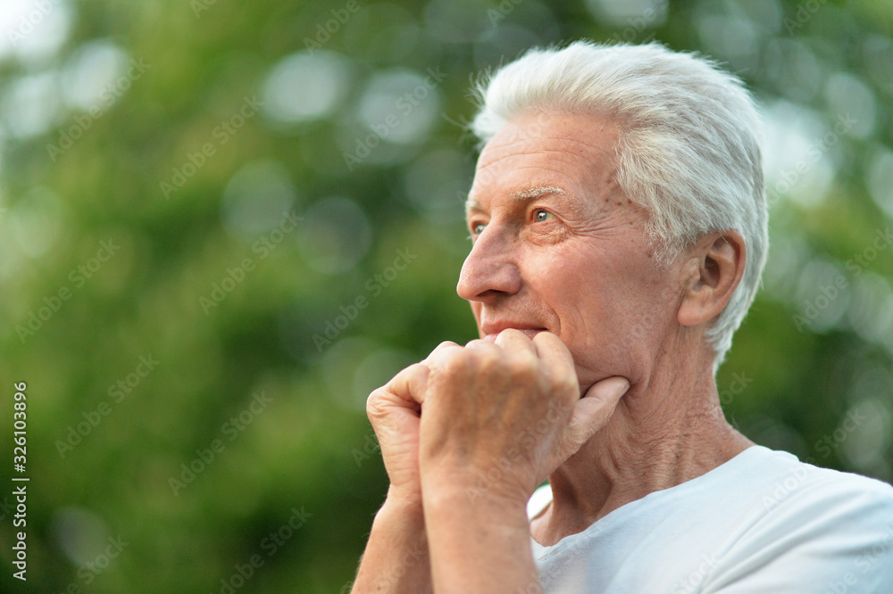 Close up portrait of smiling senior man in park Close up portrait of smiling senior man in park
