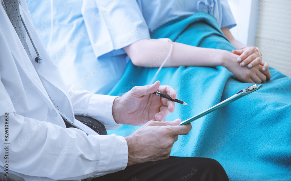 Close up of doctor diagnose young patient and give advice to patient while patient lay down on bed at examination room. Health concept Close up of doctor diagnose young patient and give advice to patient while patient lay down on bed at examination room. Health concept