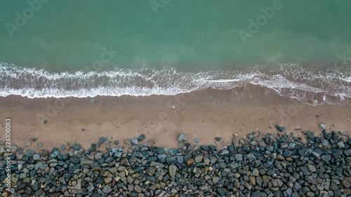 Aerial View of Waves Coming onto a Sandy Beach with Boulders - County Wicklow