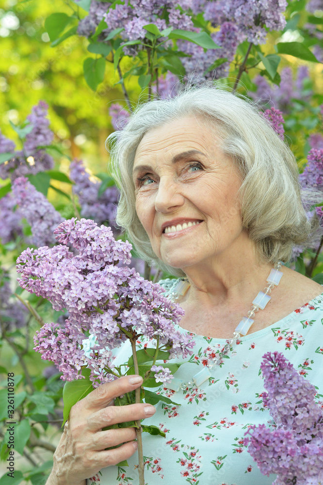 Close up portrait of happy senior beautiful woman with lilacs Close up portrait of happy senior beautiful woman with lilacs