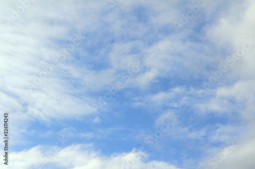 Cloudy blue sky with white and gray clouds. Background for text and design
