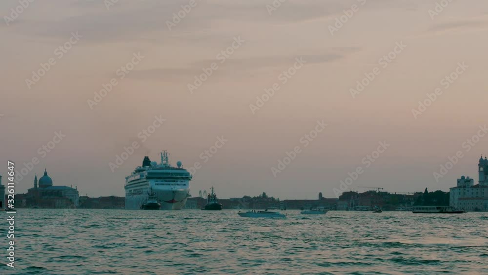 Large cruise ship being pulled towards Venice docking terminal by two large tugboats Large cruise ship being pulled towards Venice docking terminal by two large tugboats