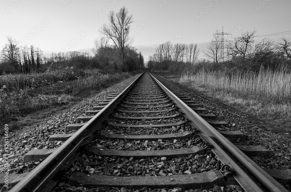 Railway lines and nature in a rural area. Black and white landscape, transportation concept