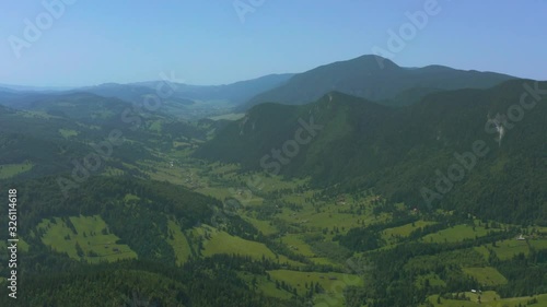 Slow pan aerial shot revealing a gorgeous, lush green valley in Carpathian Mountains photo