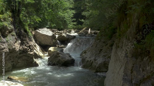 Still shot of hidden, untamed, fast mountain river and a waterfall in Carpathian mountains photo