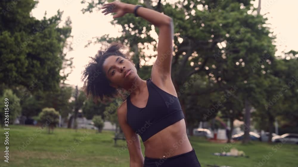 Portrait of a Healthy fit young woman stretching her arms, warming up in park Portrait of a Healthy fit young woman stretching her arms, warming up in park