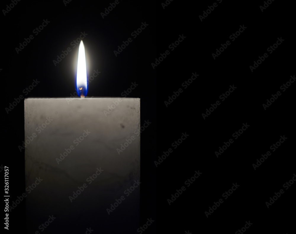 Fototapeta premium Candle flame close-up on a black background.