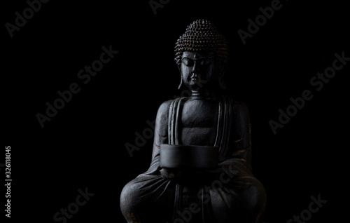 Papier peint Meditating Buddha Statue isolated on black background