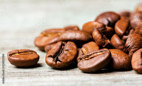 Roasted coffee beans on a wooden background  close-up  copy space.