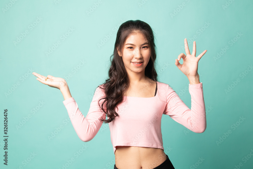 Beautiful young Asian woman show palm hand and OK sign. Beautiful young Asian woman show palm hand and OK sign.