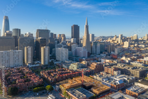 San Francisco aerial view of downtown at sunrise. Drone view facing downtown. Blue sky, golden light copy space in sky. Embarcadero and North Beach area in foreground.