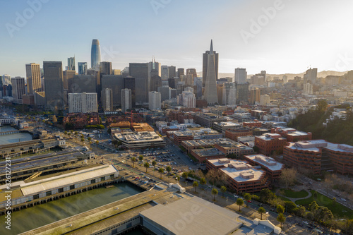 San Francisco aerial view of downtown at sunrise. Drone view facing downtown. Blue sky  golden light copy space in sky. Embarcadero and North Beach area in foreground.
