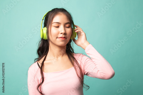 Pretty asian girl listening music with her headphones.