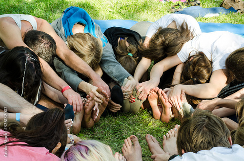 Young people do yoga outdoors sitting in a circle. Yoga festival.