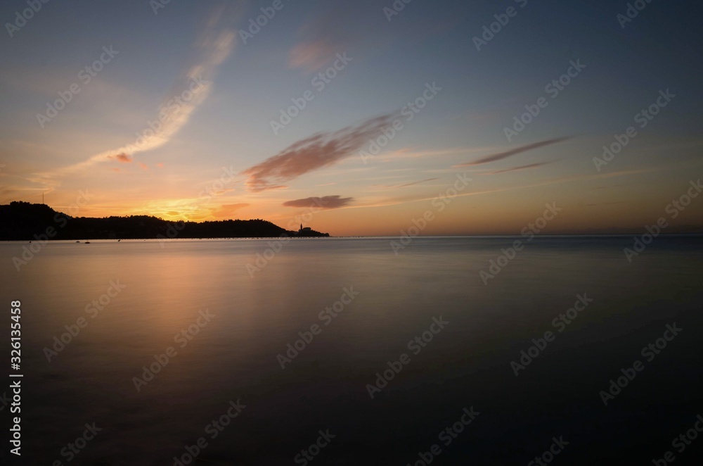 Naklejka premium Sunset behind Piran with golden sun, Slovenia