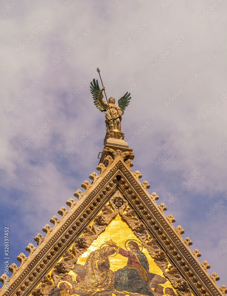 Sculptural figure of  Archangel on  roof of  basilica in  Italian city of Siena