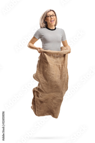 Tableau sur toile Young woman jumping in a sack