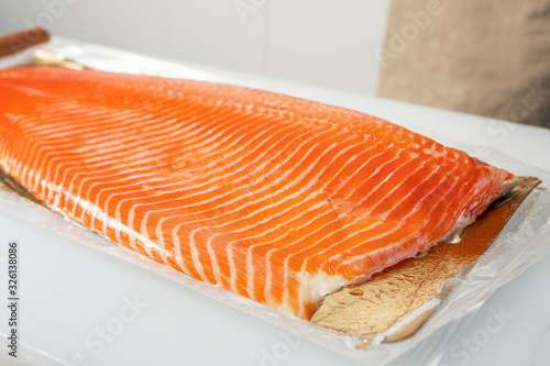 Salmon fillet in vacuum packaging on a white cutting Board. Close up.