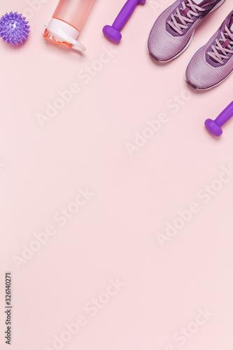 Sports equipment and shoes for women's training. Pink background, vertical picture.