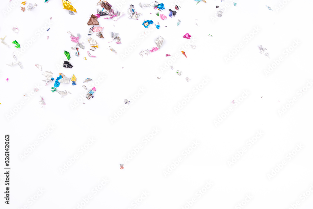 Multicolored confetti on white background. Flat lay, top view.